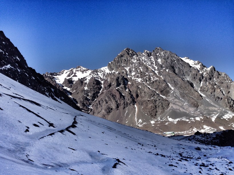 Widok ze stoków wkoło Portillo. Góra na przeciwko - to już Argentyna, zbocze po prawej - Chile. Posterunek graniczny widoczny na dole po prawej.